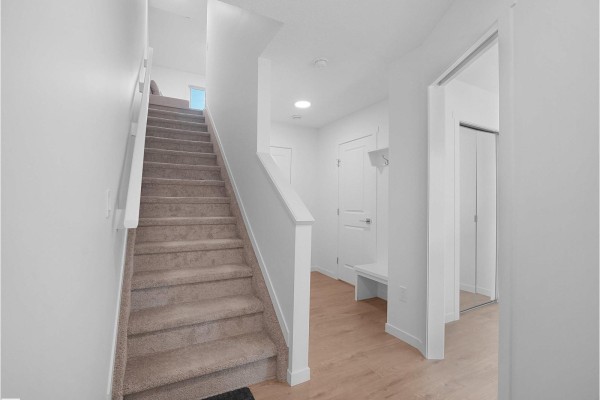 Staircase in a townhouse leading upwards, with carpeted steps and white railings. - #44 1025 Secord Promenade Pm Nw, Edmonton