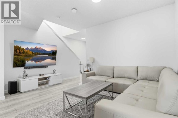 Home office with two desk chairs, dual monitors, and large windows overlooking the street. - 44 Amblefield Avenue Nw, Calgary