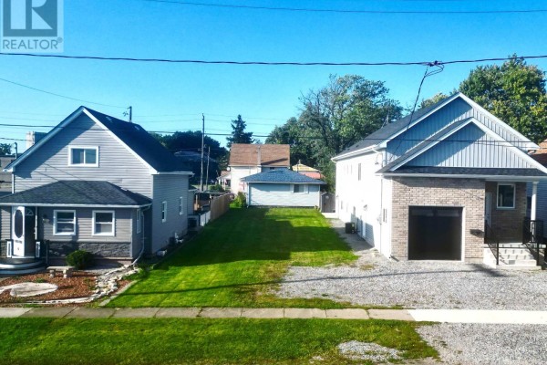 Front view of two houses with a grassy area in between and a gravel driveway. - 44 Chestnut Street, Port Colborne