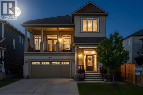 Night view of the house with illuminated porch and windows - 44 Cityside Rise Ne, Calgary