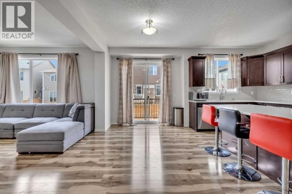 Living room featuring a sectional sofa, large windows, and open layout - 44 Cityside Rise Ne, Calgary