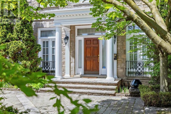 Close-up of the wooden front door with stone steps and flanking pillars. - 44 Cotswold Crescent, Toronto