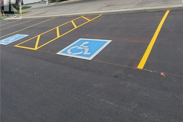 Asphalt parking lot with newly painted yellow lines and two blue wheelchair accessible parking symbols. - 44 Ditton Drive Unit# 3, Hamilton