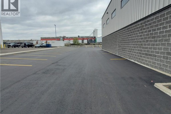 View of a long, newly paved asphalt parking lot with yellow painted lines beside a commercial building. - 44 Ditton Drive Unit# 3, Hamilton