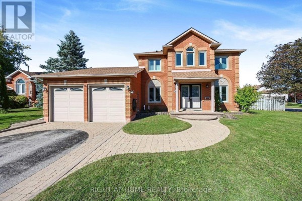 Brick two-story house with double garage and arched windows under a bright sky. - 44 Edenbridge Drive, Essa