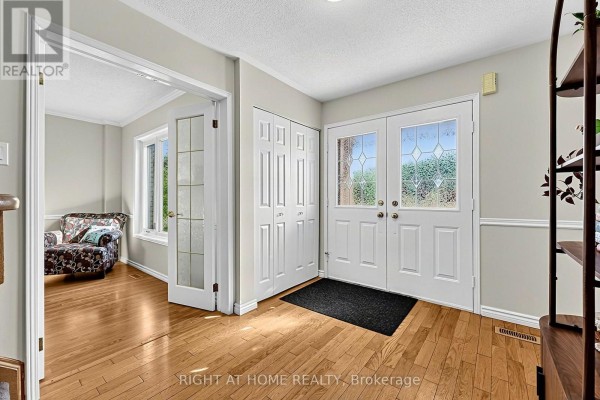 Interior view of the entrance hall showing double front doors and a doorway to a living area. - 44 Edenbridge Drive, Essa