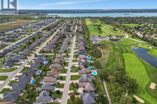Aerial view of a suburban neighborhood with houses, a golf course, and a large body of water. - 44 Hilton Court, Amherstburg