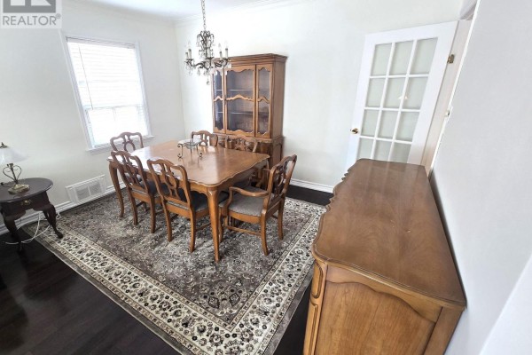 Dining room with wooden dining set, hutch, sideboard, and patterned area rug. - 44 Janet Boulevard, Toronto