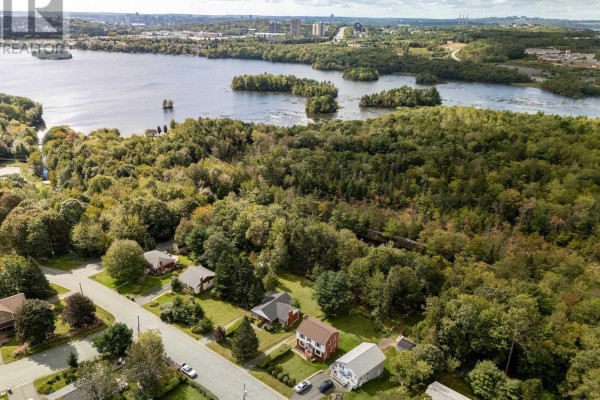 Aerial view of residential street with houses surrounded by trees and a large body of water. - 44 Locks Road, Dartmouth