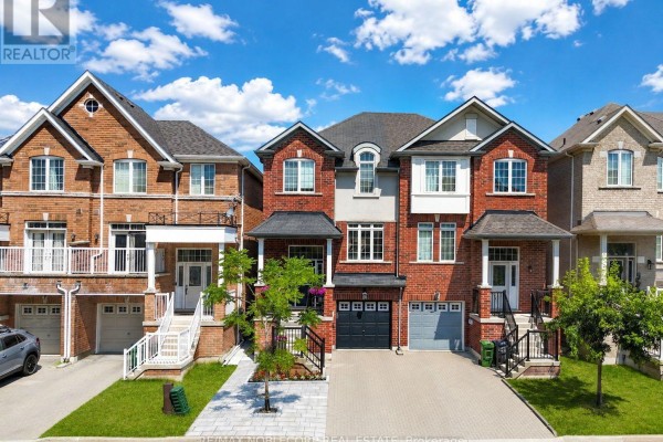 Daytime exterior view of red brick townhouses with manicured lawns and paved driveways. - 44 Lou Pomanti Street, Toronto