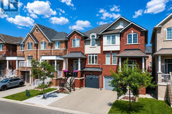 Front exterior of red brick townhouses showing multiple garages and upper-level balconies. - 44 Lou Pomanti Street, Toronto