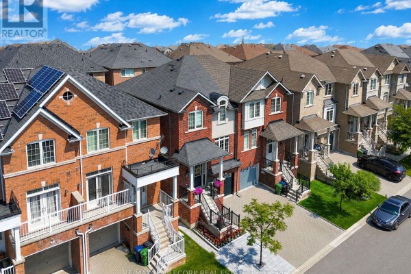 Aerial view of a street lined with red brick townhouses under a blue sky. - 44 Lou Pomanti Street, Toronto