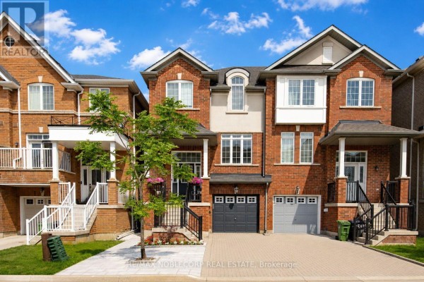 Close-up exterior view of the central townhouse, highlighting the entrance and garage. - 44 Lou Pomanti Street, Toronto