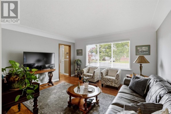 Living room with a sofa, armchairs, large window, and a coffee table. - 44 Mccrea St, Sault Ste  Marie