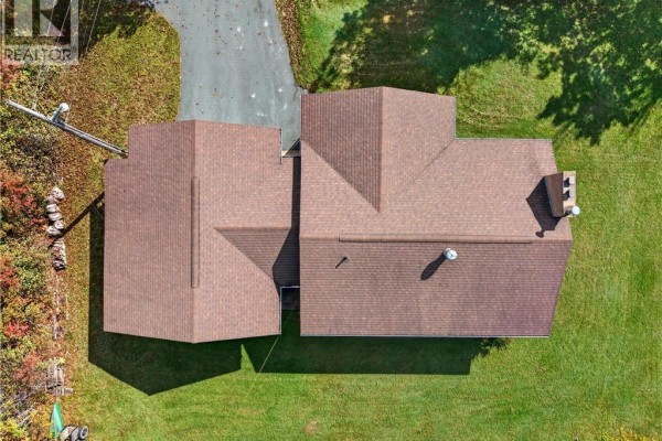 Aerial view of a bungalow with a brown shingled roof and a connected garage. - 44 Nelson Street, Miramichi