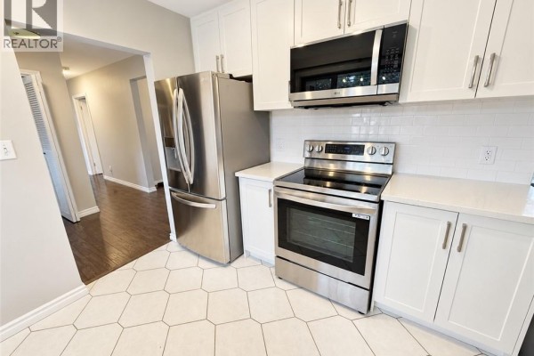 Living and dining area with dark wood floors and floor-to-ceiling windows. - 44 Patterson Avenue Unit# A, Brantford