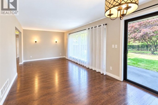 Backyard with a green lawn, gazebo, mature trees, and asphalt patio. - 44 Patterson Avenue Unit# A, Brantford