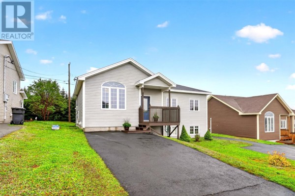 Front exterior view of a grey split-level house with a dark wood deck and railing. - 44 Seascape Drive, Paradise