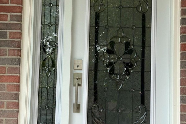 Close-up of a white front door with ornate stained-glass panels and a silver handle. - 44 Sylvia Street, Barrie