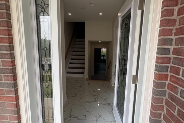 View from the front door into a hallway with light marble tile floors and a staircase. - 44 Sylvia Street, Barrie