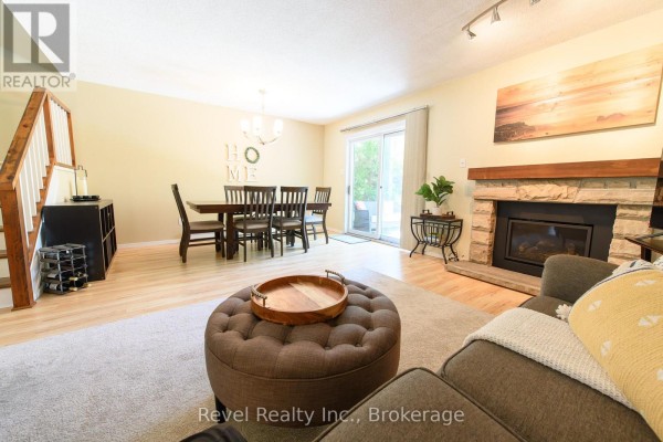 Kitchen with dark wood cabinets, stainless steel appliances, and light granite countertops. - 440 Oxbow Crescent W, Collingwood