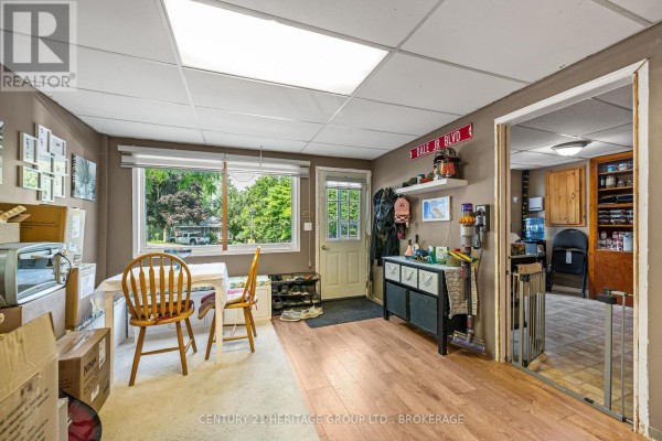 Room with light wood laminate flooring, a table with chairs, and an open doorway. - 4400 William Street, Frontenac