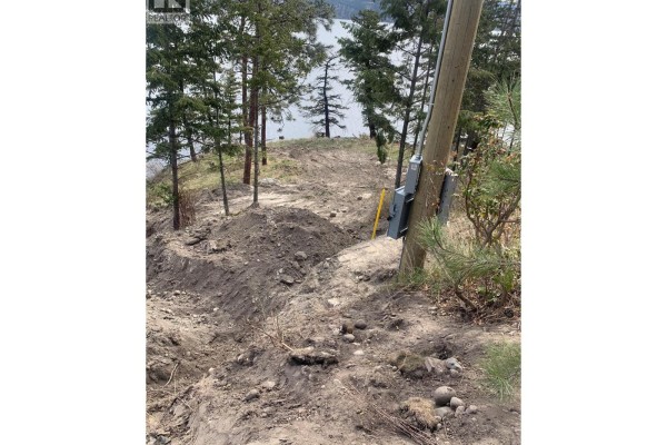 Dirt path and trenches on a sloped property with trees and a utility pole with electrical boxes. - 4401 Westside Road Unit# Lot 22, Kelowna