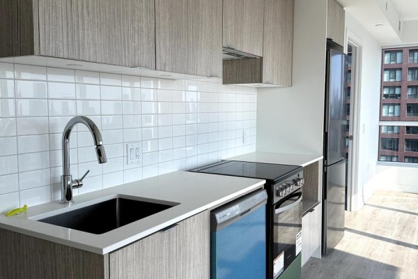 Kitchen area with sink, faucet, dishwasher, stove, and wood-look cabinetry against a tiled backsplash. - 4402 - 395 Bloor Street E, Toronto