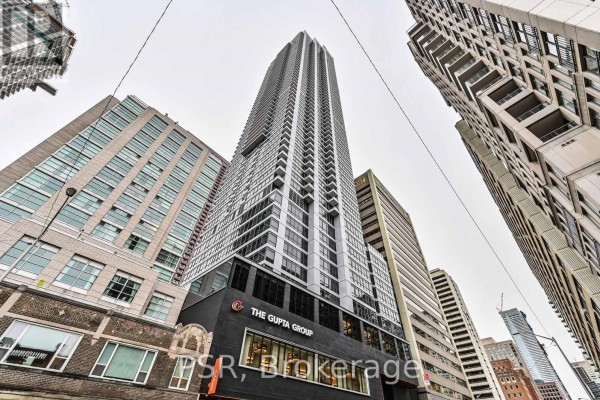 Looking up at a tall residential building with geometric facade details. - 4409 - 395 Bloor Street E, Toronto