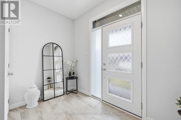 Interior view of the front door with frosted glass panels and a large arched mirror on the right. - 441 Sterling Avenue, Clarence Rockland