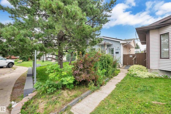 Front exterior of a light blue house with vinyl siding and grass. - 442 Kirkpatrick Cr Nw, Edmonton