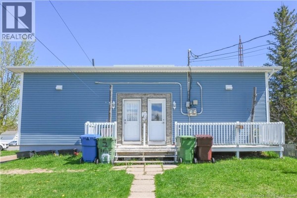 View of a blue house and a white barn-style shed in a grassy yard. - 443 Chemin Haut-shippagan Road, Haut Shippagan