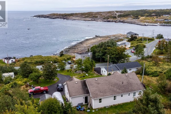 Aerial view of the house and its coastal surroundings, featuring ocean views and rugged shoreline. - 443 Wind Gap Road, Flatrock