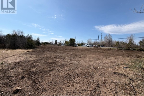 Expansive cleared lot with brown soil and tire tracks, bordered by trees and utility poles. - 4431 Baseline Road W, Georgina