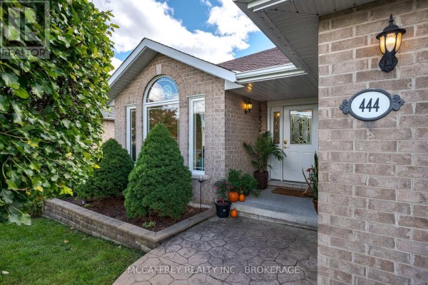Front entrance of a brick house with a decorative arched window and stone pathway. - 444 Bridge Street W, Greater Napanee