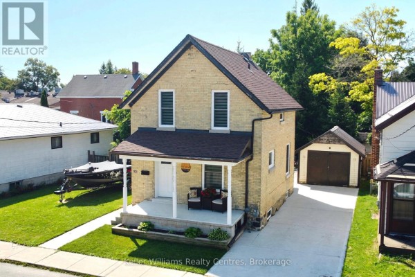 Aerial view of a two-story yellow brick house with a detached garage and a boat on trailer in the yard. - 445 11th Street, Hanover