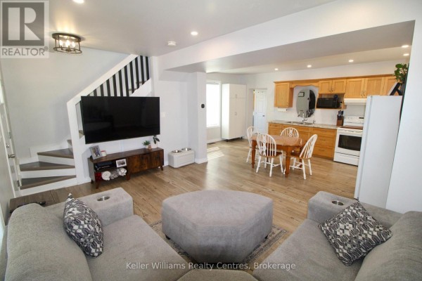 Open-concept living room and kitchen area with light wood cabinets and dining table. - 445 11th Street, Hanover