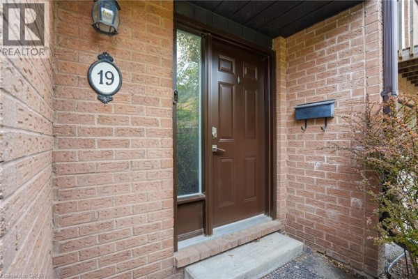 Front door of brick townhouse with house number 19 and mailbox. - 445 Stone Church Road W Unit# 19, Hamilton