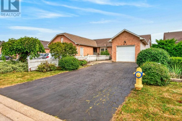 Wide exterior shot showing the townhouse, driveway, fire hydrant, and surrounding greenery. - 4459 Christopher Court, Lincoln