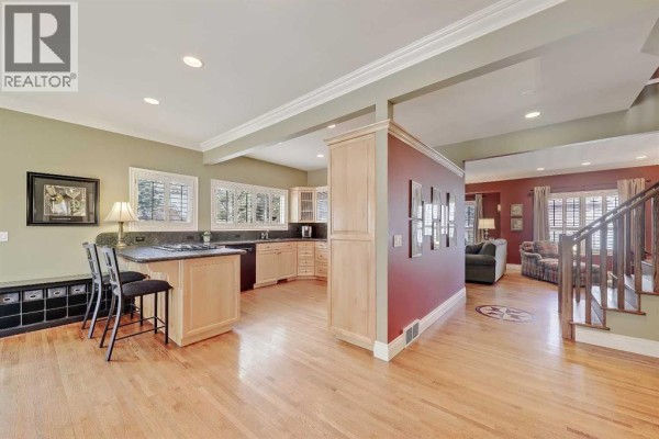 Open concept kitchen and living area with hardwood floors and large island. - 446 Killarney Glen Court Sw, Calgary