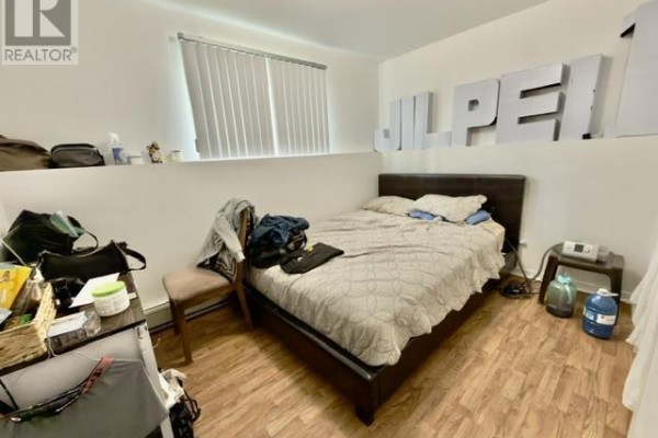 Bedroom with a bed, window with blinds, and large "JILPEI" wall decor. - 446 Maddix Crescent, Summerside