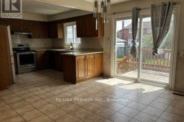 Kitchen with wooden cabinets, stainless steel appliances, and deck access - 4464 Stonemill Court Mississauga