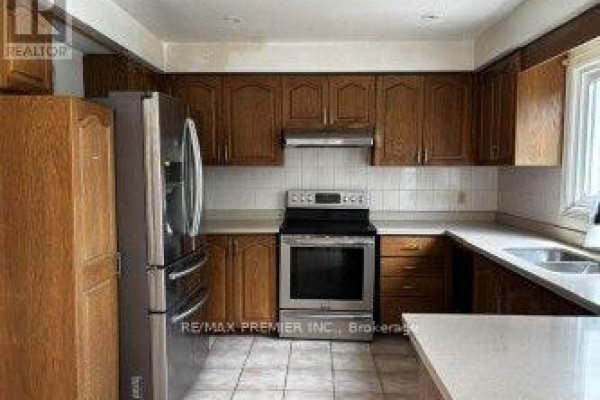 Kitchen with oak cabinets, stainless steel appliances, and white countertops - 4464 Stonemill Court Mississauga