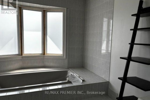 Soaking tub and bay window in bathroom with ladder shelf - 4464 Stonemill Court Mississauga