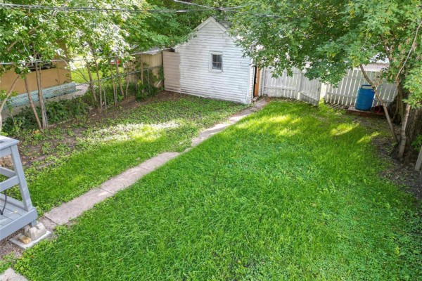 Empty room with light beige walls, white trim, and wood-look vinyl flooring. - 447 12th Street, Brandon