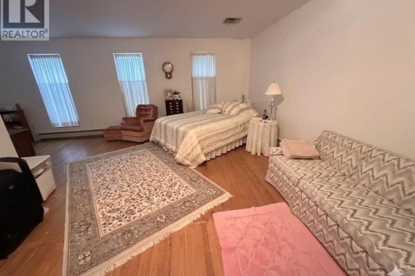 Bedroom with bed, sofa, armchair, ottoman and rugs - 4470 Riverside Windsor