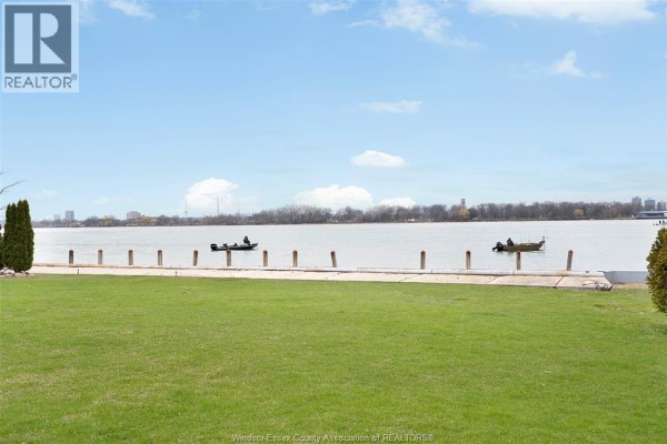 Waterfront view with lawn, boats, and city skyline - 4470 Riverside Windsor