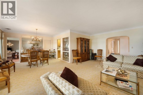 Living and dining room with upholstered sofas, hutch, and chandelier - 4470 Riverside Windsor