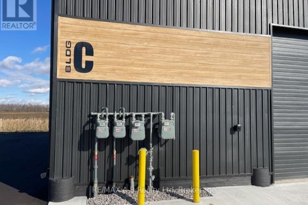 Close-up of four gas meters mounted on the black metal exterior wall of Building C. - 44726 Line 34 Line, Huron East
