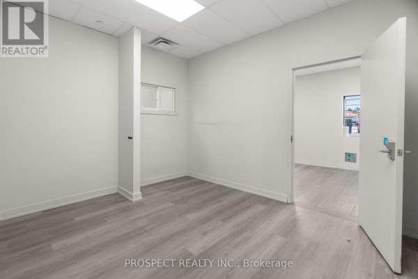 Hallway with multiple doors and stairs leading to a second level. - 44d - 4000 Steeles Avenue, Vaughan